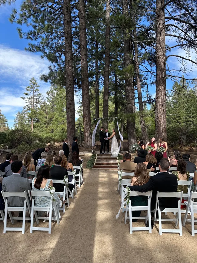 Couple exchanging vows beneath a floral wedding arch