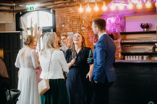 Wedding guests chatting over drinks at cocktail hour